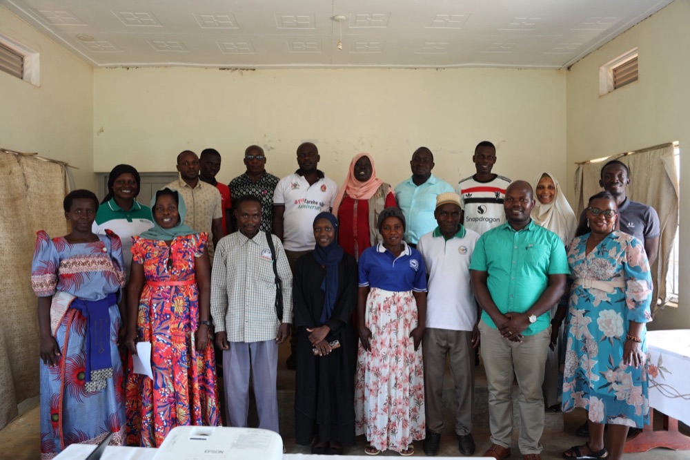 Community participants and Makerere University staff photographed together at a community workshop at an upcountry venue.