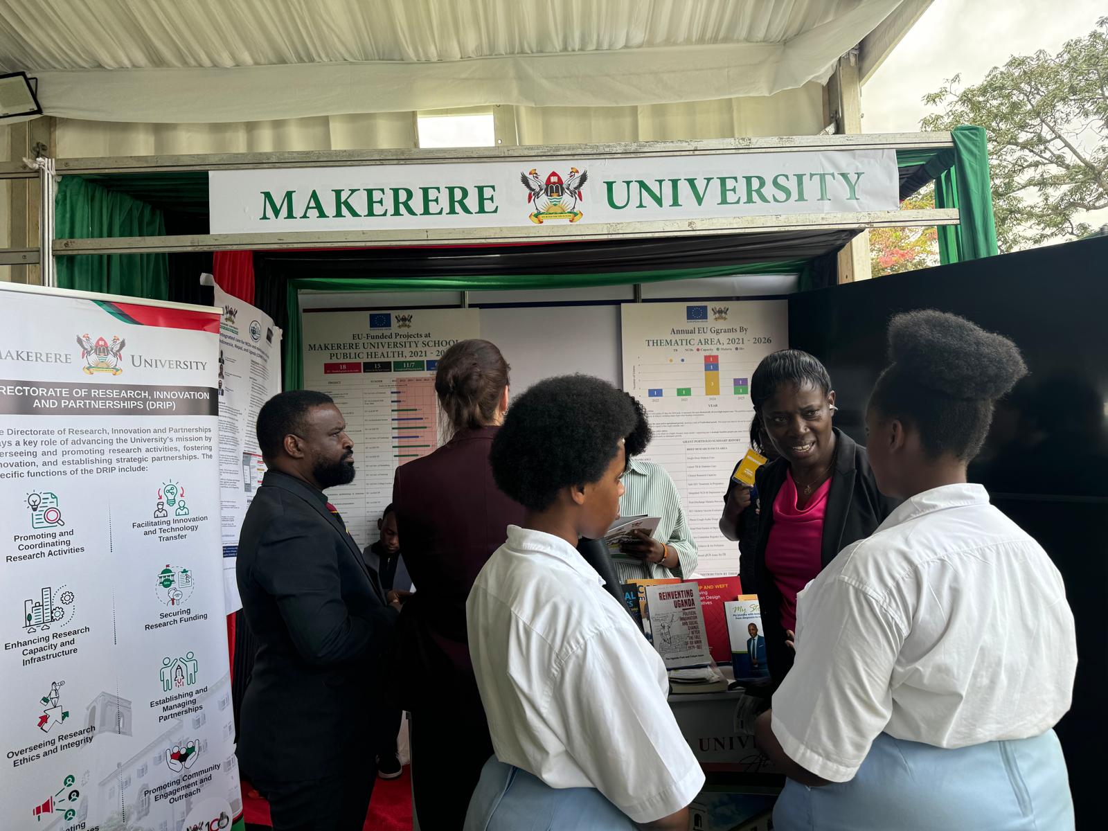 Visitors engage with the Makerere University team at the Mak-RIF and DRIP stand during the fair.